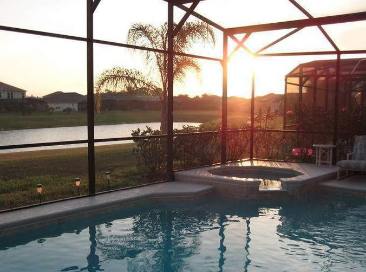 Picture of a pool cage during sunset sitting close to a river bank.